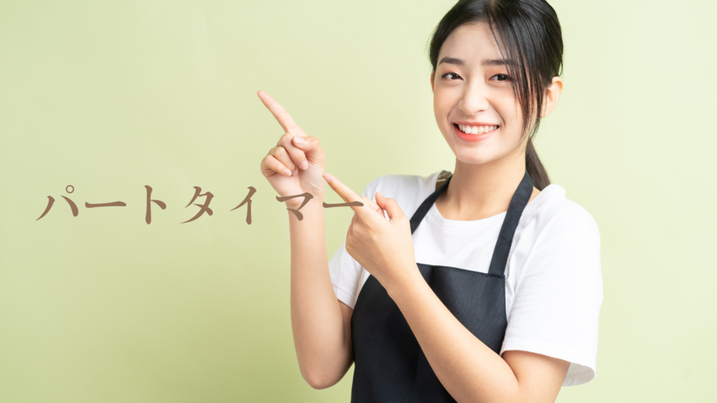 白いTシャツに黒エプロン姿の女性が右上を両人差し指で指しながら笑顔でこちらを見ている