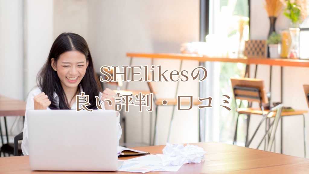 カフェでパソコンを開きながらガッツポーズをとるロングヘアの女性