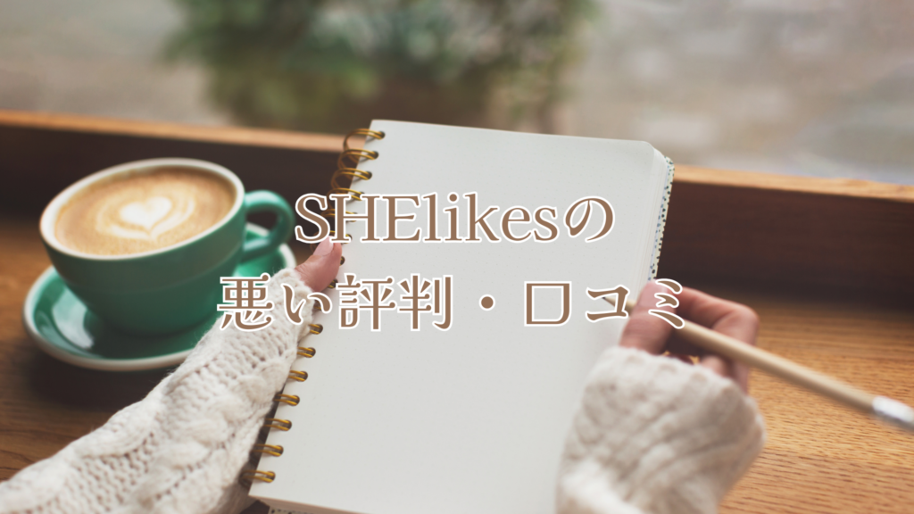 緑のカップのカフェラテを奥に置いて、白ニットの女性がメモ帳と鉛筆を持っている手元