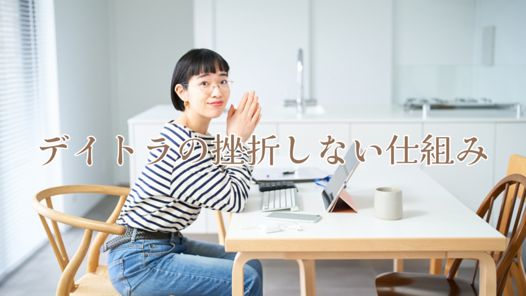 ボーダーの服を着た女性がパソコンを開きながらこちらを見ています