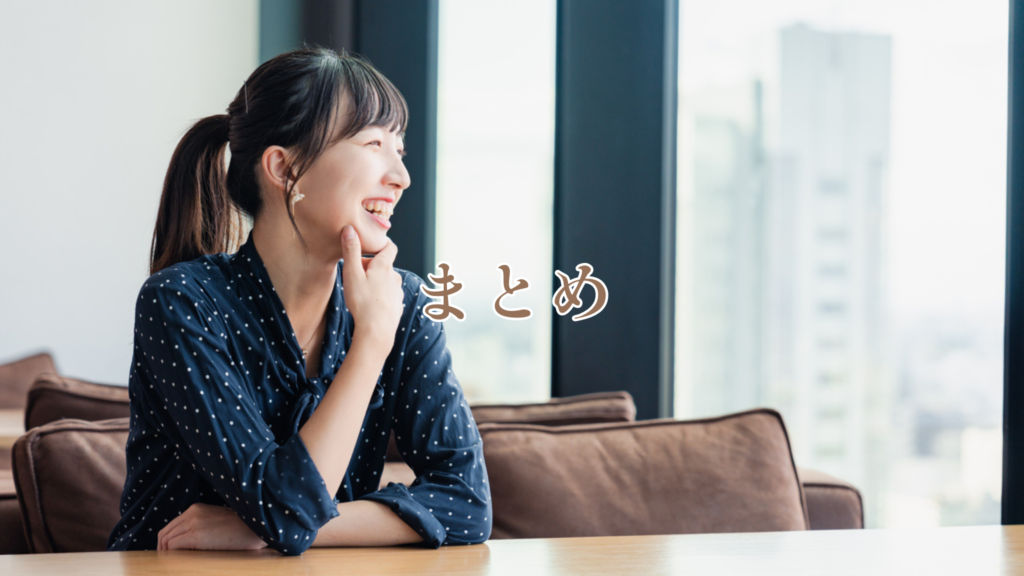 紺色の水玉柄のブラウスを着たポニーテールの女性が笑顔で外を眺めています