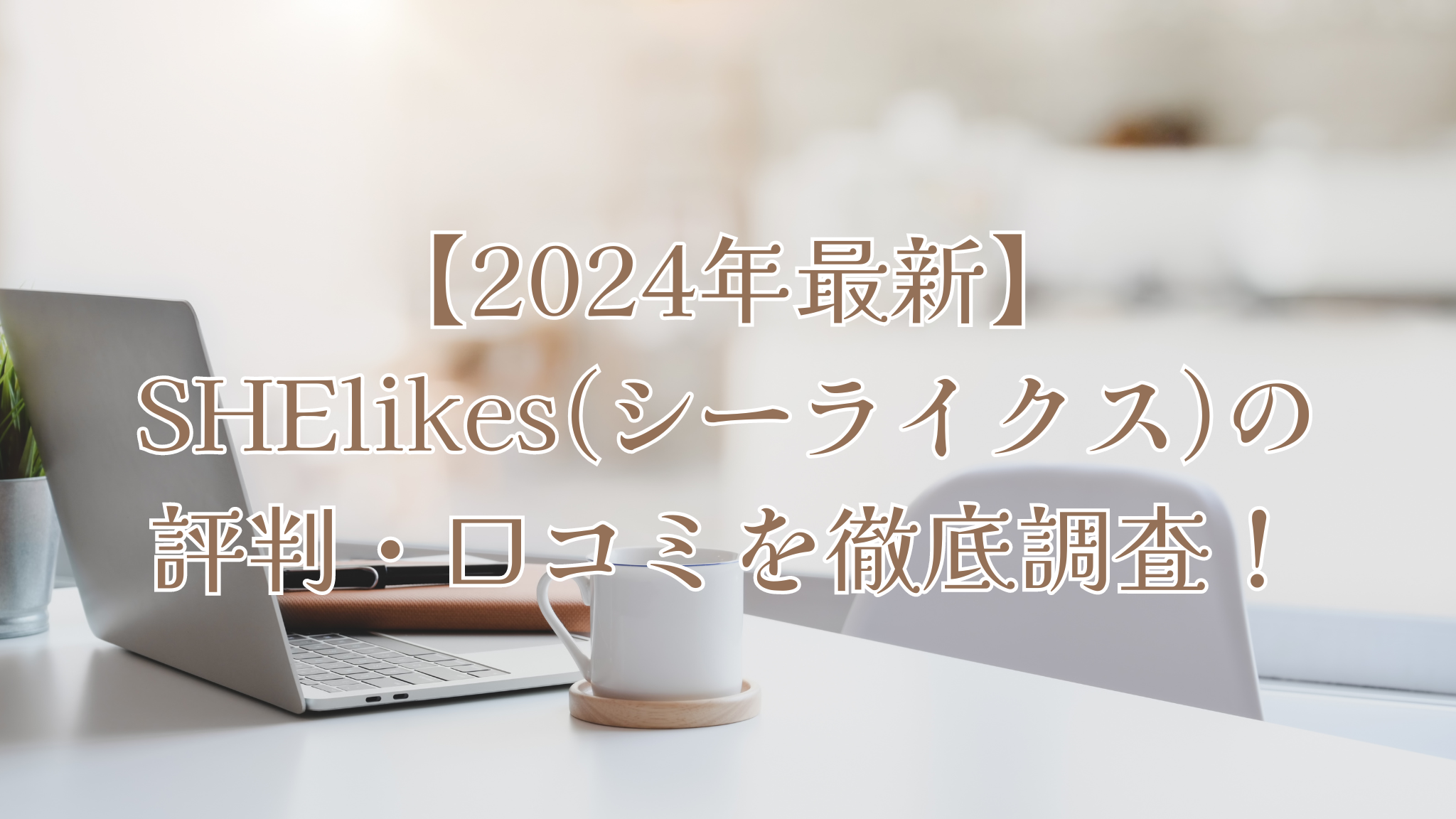 白いデスクの上にシルバーのノートパソコンと白いマグカップと、デスクチェア